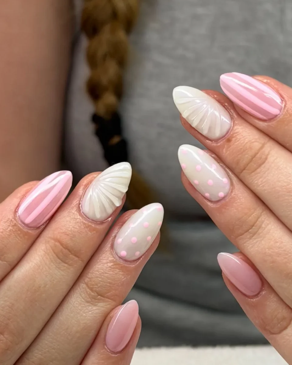 Almond nails in soft pink and white: pink and white stripes, white 3D seashells, milky white with pink dots, and sheer pink