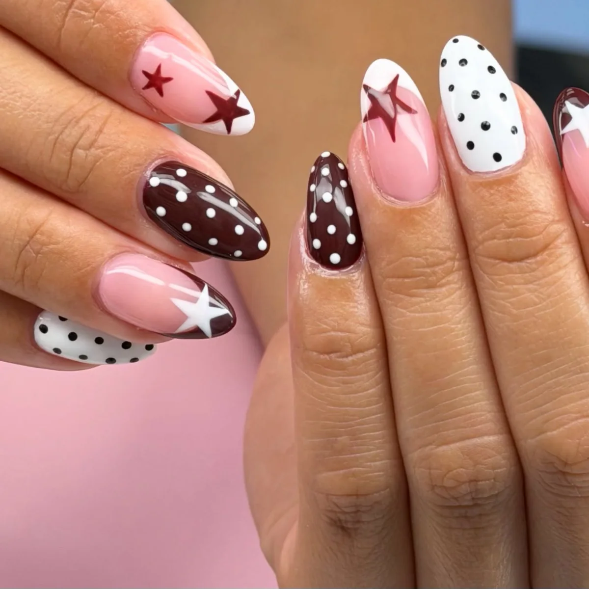 Almond nails: white with black polka dots, burgundy with white polka dots, and sheer pink with burgundy and white stars
