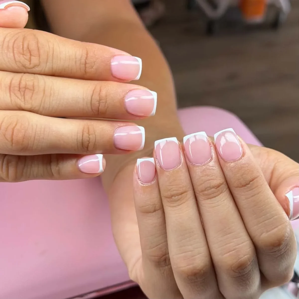 Short square nails with classic white French tips on a sheer pink base