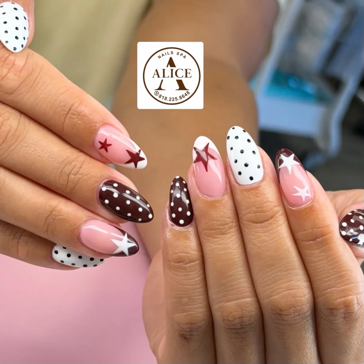 Almond nails: white with black polka dots, burgundy with white polka dots, and sheer pink with burgundy and white stars