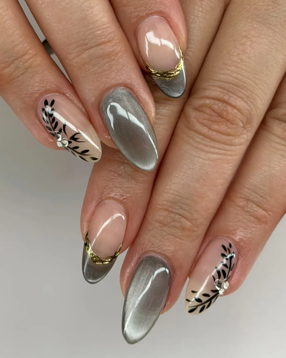 Almond nails in grey cat-eye, nude with grey cat-eye French tips edged in gold foil, and nude with black painted leaves and rhinestones