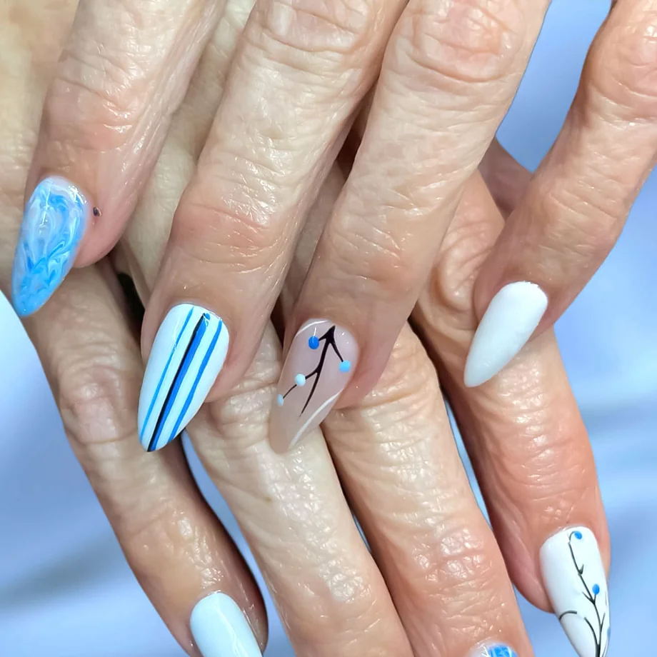 Almond nails in sky blue marble, blue and white stripes and white with a hand-drawn branch