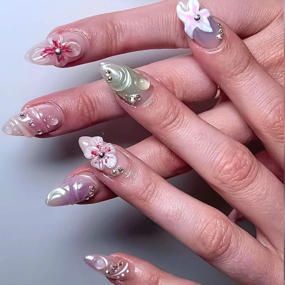 Nude almond nails with white 3D flowers, chrome and rhinestones