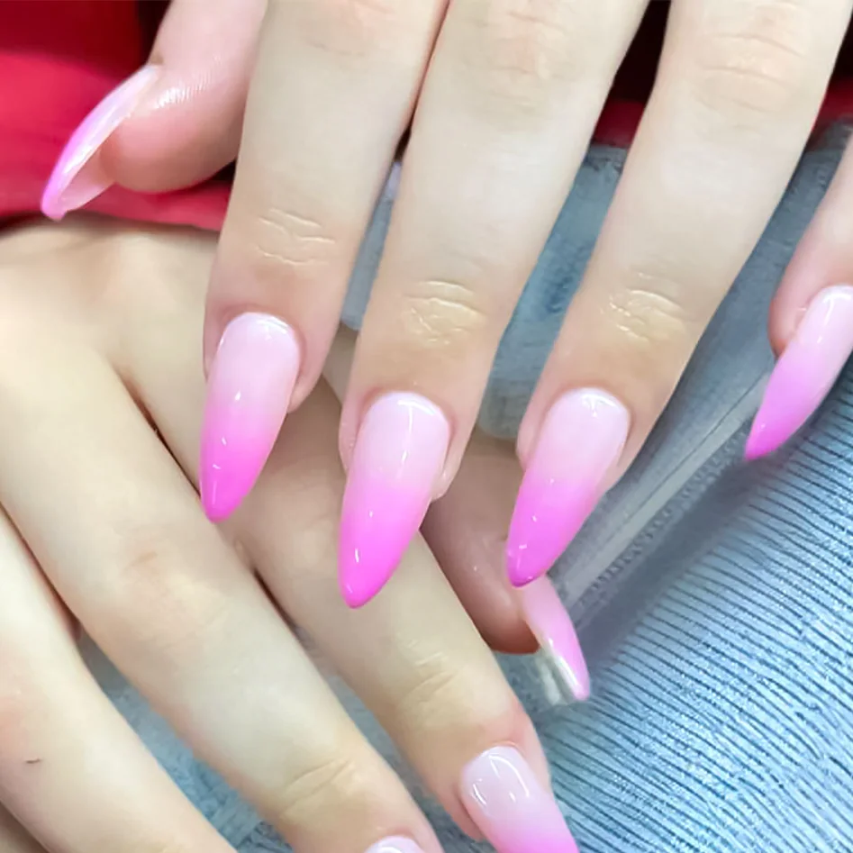 Long stiletto nails in an ombré from pale pink to hot pink